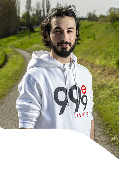 operaio edile con felpa bianca e sfondo campi verdi