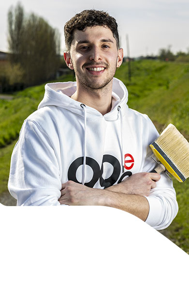 operaio edile con felpa bianca e sfondo campi verdi